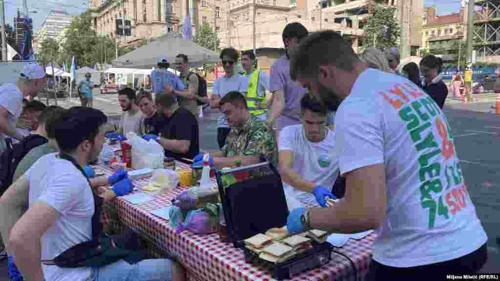 Pravljenje sendviča u toku. Studenti Mašinskog fakulteta su doneli hleb, sir, suhomesnate proizvode, namaze i toster.Sa ovog fakulteta objašnjavaju da su se studenti priključili protestu ispred Vlade, kojim je u tom delu grada blokiran saobraćaj, kako bi podržali zahteve "Pobunjenog univerziteta".