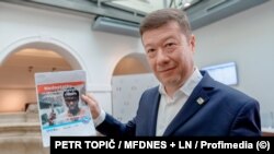 Tomio Okamura cu o copie A4 a billboardului care i-a adus dosar penal.