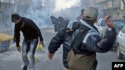 Demonstranti bacaju kamen na policiju za razbijanje demonstracija tokom protesta protiv Vlade u Teheranu, 14. februar 2011.