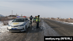 Сотрудники полиции и их служебный автомобиль в селе Абай Кызылординской области. 17 января 2019 года.