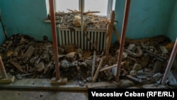 Resturi de tavan căzute într-un fost salon.