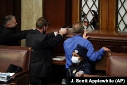 Охранители на конгресмените насочват оръжия срещу опитващи да нахлуят в пленарната зала