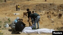 Palestinezët gjejnë trupa të varrosur në një varr masiv gjatë konfliktit të tanishëm mes Izraelit dhe Hamasit, në veri të Gazës, 15 prill 2024.