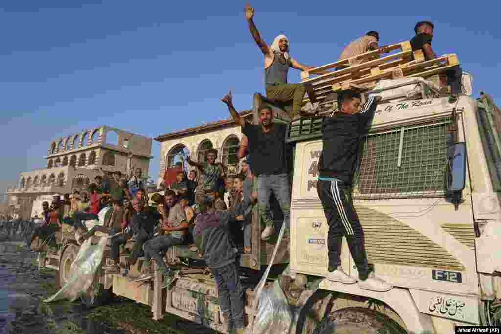 Palestinezë duke udhëtuar me një kamion që u solli ndihma.