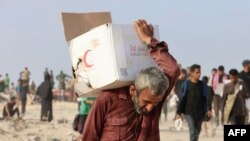 Palestinac nosi kutiju sa pomoći u Džabaliji 22. jula 2025. godine.