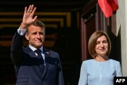 Președintele Franței, Emmanuel Macron, salută mulțimea adunată în fața Președinției de la Chișinău, pe 27 august 2025, fiind întâmpinat de președinta Republicii Moldova, Maia Sandu.