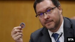 Вътрешният министър Даниел Митов показва магнитче с икона, което по думите му е поръчано от МВР за кампания по пътна безопасност по времето на служебния министър Иван Демерджиев, но заради по-стара заповед на неговия предшественик Бойко Рашков, 28 май 2025 г.