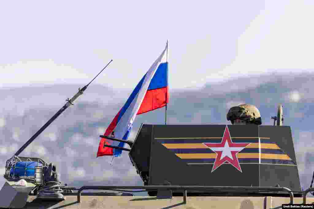 Un trăgător rus în turela unui vehicul blindat care se îndreaptă&nbsp;spre baza aeriană Hmeimim. &bdquo;Comunicarea cu soldații ruși nu este posibilă&rdquo;, spune fotograful Umit Bektas: &bdquo;Nu răspund la întrebări și nu te lasă să te apropii. Par încordați, dar nu furioși, nu au manifestat vreun semn de agresiune, își păstrează calmul&rdquo;.