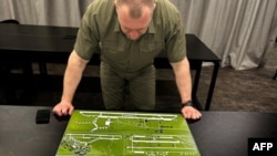 Глава Службы безопасности Украины Василий Малюк рассматривает карту, на которой изображена российская военная авиабаза, 1 июня 2025 года