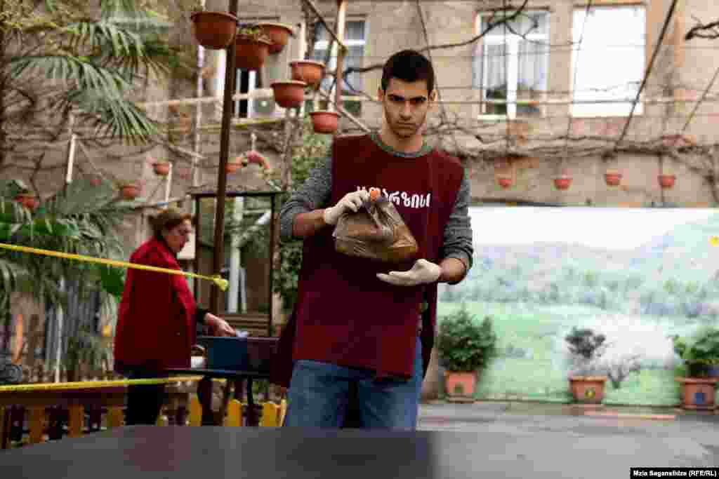 &quot;კათარზისის&quot; თანამშრომელი საკვების თითო პორციას მაგიდაზე დებს.