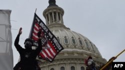 Протетиращи с противогази, издигнали знамето “Роден, отгледан и защитаван от Бог, оръжия, смелост и слава“.