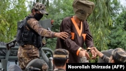 FILE: Afghanistan's National Directorate of Security (NDS) agents escort alleged Taliban and Islamic State (IS) fighters after they are presented to the media in Jalalabad on May 23.
