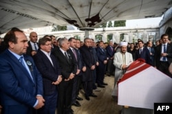 Binali Yıldırım török miniszterelnök és Ahmet Davutoğlu volt török miniszterelnök áll a legendás háromszoros olimpiai aranyérmes török súlyemelő, Naim Süleymanoğlu koporsója mellett Isztambulban, a 2017. november 19-én tartott gyászszertartáson