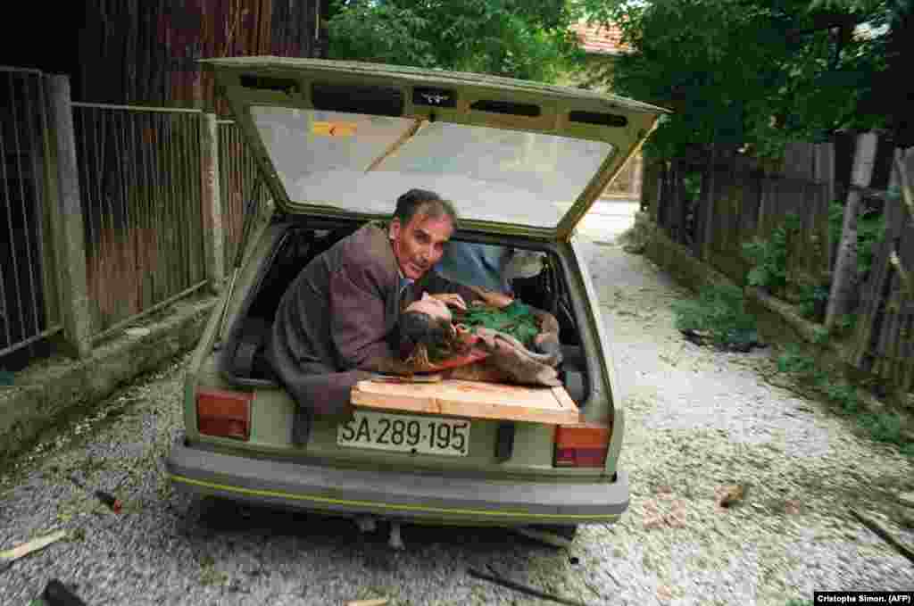 Čovjek drži glavu žene ranjene u granatiranju, 27. juni 1992.&nbsp;