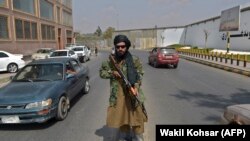 A Taliban fighter stands guard along a street near in Kabul, September 23, 2021.