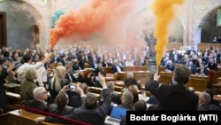 A Momentum képviselői a szavazás előtt tiltakozásul piros-fehér-zöld füsttel borították be az üléstermet 2025. március 18-án