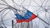 Ruska zastava se vijori iza ograde i bodljikave žice (ilustrativna fotografija)