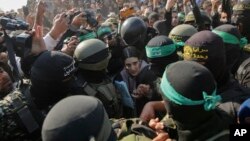 Боевики ХАМАС сопровождают Арбель Йехуд во время передачи представителям Красного Креста в Хан-Юнисе, 30 января 2025 г.