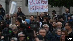 Participanții la un protest în culori gri, adunați cu placate anti-Fidesz, pe 15 aprilie, în fața Palatului Sándor, sediul președinției din Ungaria.