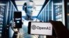 Logoja e OpenAI shihet në ekranin e një telefoni mobil me një imazh në ekran kompjuterik të gjeneruar nga ChatGPT.
