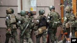 Militari ruși merg pe o stradă din Rostov-pe-Don, Rusia, sâmbătă, 24 iunie 2023.