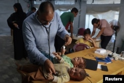 Egy orvos vizsgálja meg az ikreket a menekülttáborban 2025. szeptember 18-án