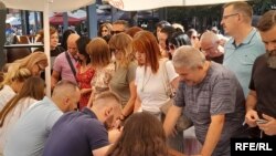 Disa qytetarë serbë duke nënshkruar peticionin kundër ndërtimit të dy urave në Mitrovicë, 7 korrik 2025.