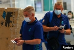 Belarusian Olympic officials Artur Shumak (left) and Yury Maisevich wait at Haneda airport to board a flight home from Tokyo on August 6.
