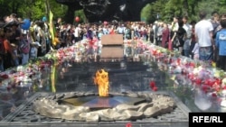 Алматыдағы 28 панфиловшы жауынгер саябағындағы мәңгілік алауға гүл қойып жатқан жұрт. Азаттық архивіндегі фото.