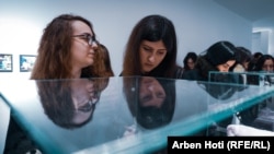 Posetioci gledaju izložene eksponate - među njima i jedan peškir.