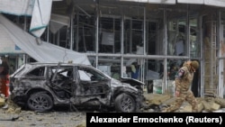 La 10 ianuarie, un anchetator se plimbă pe lângă un magazin avariat în urma bombardamentelor din orașul ocupat Donețk, pe care autoritățile locale instalate în Rusia le-au numit un atac militar ucrainean.