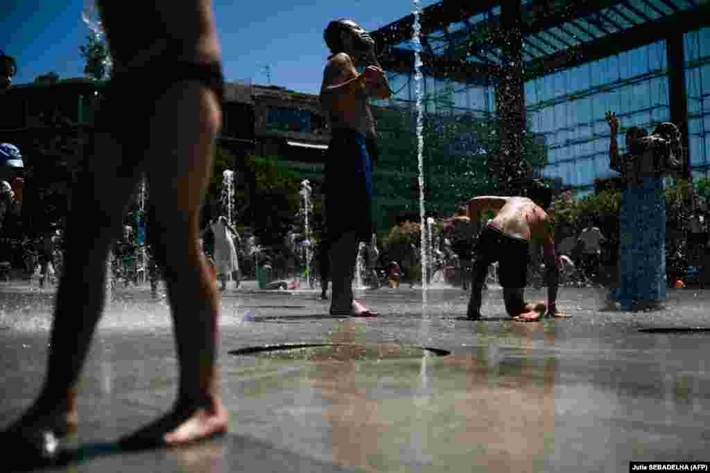 Ljudi se rashlađuju u fontani u javnom parku Andre-Citroen u Parizu, Francuska, 29. juna 2025. godine.