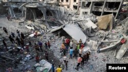 Palestinezë duke inspektuar vendin e një sulmi izraelit mbi një shtëpi, në Jabalia, në veri të Rripit të Gazës, më 18 maj 2025.