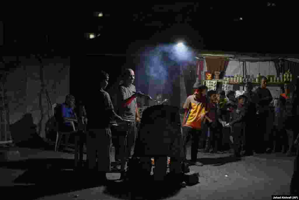 Një burrë palestinez duke përgatitur ushqim afër plazhit, në një kamp për të zhvendosurit.