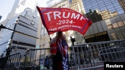 Un suporter al învingătorului alegerilor din SUA în fața clădirii Trump Tower, din New York. 6 noiembrie 2024.