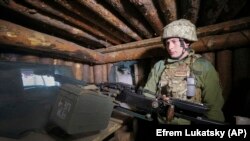 Ukrán katona tüzelőállásban Kelet-Ukrajnában, a hadsereget az oroszbarát szeparatistáktól elválasztó vonal mentén, 2021. április 16-án