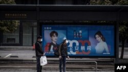 Qytetarët në Vuhan të Kinës presin në një stacion të autobusëve. Mars, 2020. 