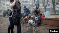 Residents of a heavily damaged 18-story apartment building gather outside following a Russian missile strike in Kyiv and other regions on February 7.