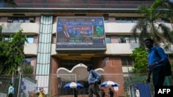 Pješaci prolaze pored ekrana bombajske berze u Mumbaiju 3. marta 2025., emitujući vijest o odluci Donalda Trumpa o uvođenju većih recipročnih carina.