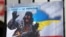 Плакат с изображением Владимира Путина в виде «зеленого человечка» во время акции «Крым – это Украина» у российского посольства в Киеве, 16 марта 2020 года 