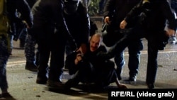 პოლიციელები ფეხით სცემენ დაკავებულ დემონსტრანტს. 29 ნოემბერი, 2024 წელი