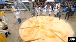 Membrii Frăției Omletei Uriașe din Bessières gătesc o omletă uriașă în cadrul sărbătorilor pascale, pe 28 martie 2016