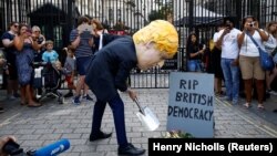 Demonstrant sa maskom britanskog premijera ispred njegove rezidencije u Downing Streetu u Londonu