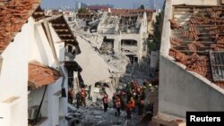 Спасителни отряди търсят оцелели хора в израелския град Ришон ле Цион, ударен от иранска ракета. Техеран бомбардира Израел в отговор на ударите на Тел Авив по обекти на иранската ядрена програма и ликвидирането на ядрени учени и военното ръководство на страната. 14 юни 2025 г.