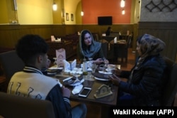 Tineri - bărbați și femei - discută la o ceașcă de ceai într-un restaurant din Kabul, în ianuarie 2019.