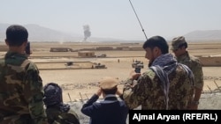 Afghan military officers watch clashes in Takhar in August. 