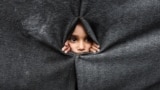 Raseljeno palestinsko dijete gleda kroz zaklon napravljen od ćebadi u školi koju vodi UNRWA nakon što je američki predsjednik Donald Trump objavio da su se Izrael i Hamas složili oko prve faze primirja u Gazi, Han Junis na jugu Pojasa Gaze, 9. oktobar 2025. 