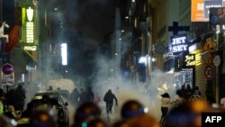 Демонстрантите трчаат откако француските полицајци употребија солзавец во Париз на 2 јули 2023 година, на петтиот ден од протестите откако 17-годишен маж беше убиен од полицијата во Нантер