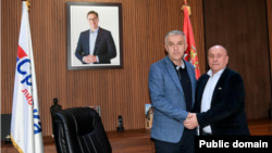 Lider Srpske liste Zlatan Ellek and Srećko Spasić pored fotografije predsednika Srbije Aleksandra Vučića, 3. novembar 2025.