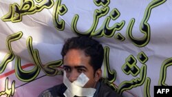 FILE: A Pakistani journalist takes part in a protest against the government fines and restrictions in 2014.